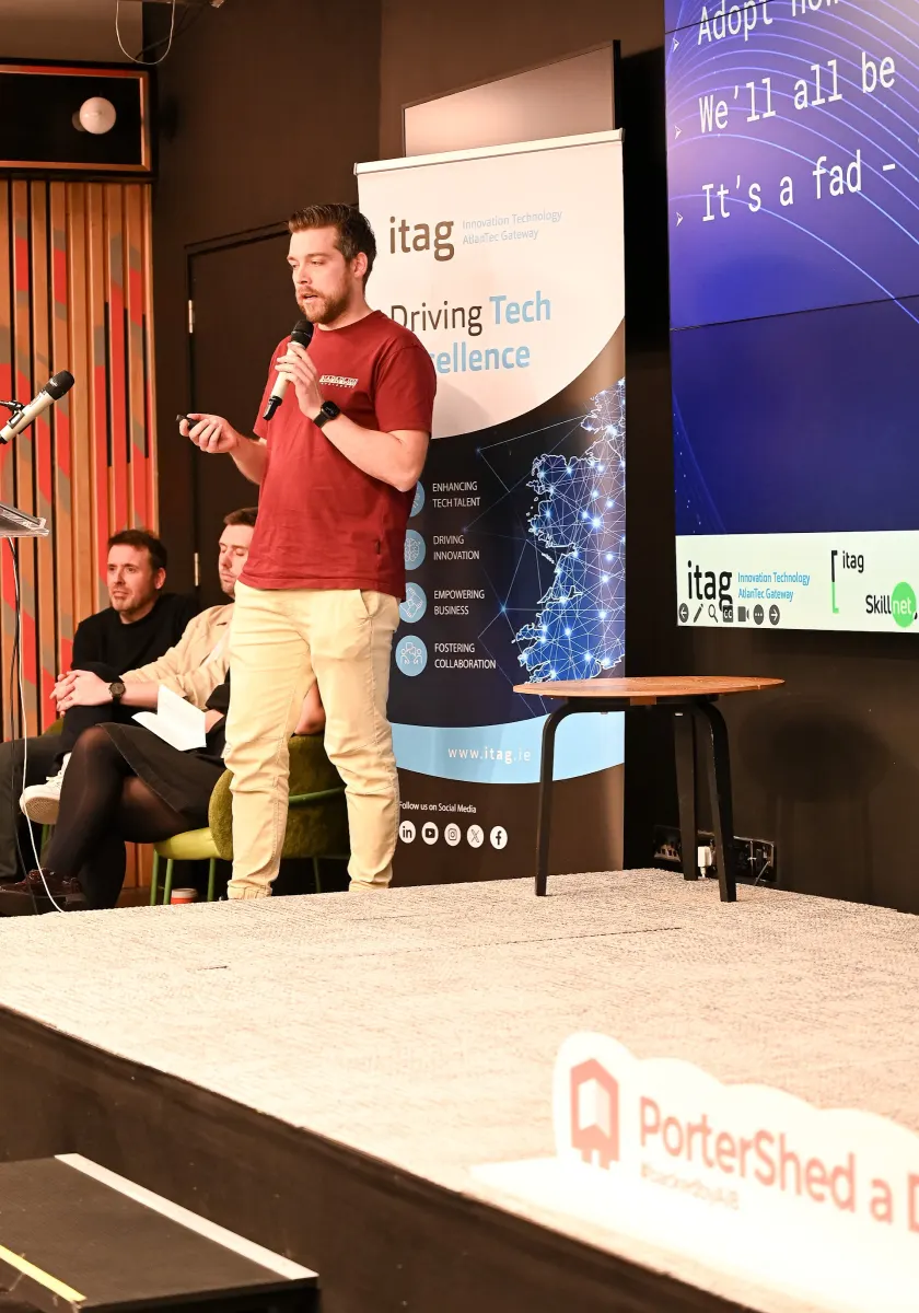 Cillian speaking into a microphone on stage at the PorterShed